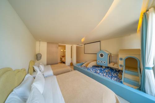 a toy room with two beds and a play kitchen at 礼橖LoveTime·美学海景民宿（较场尾大鹏所城店） in Shenzhen