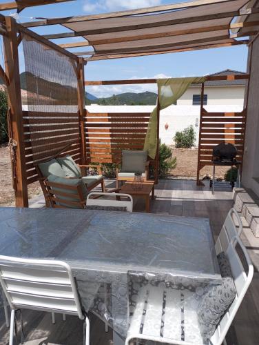 une table et des chaises sur une terrasse avec pergola dans l'établissement Casa Di sardhina, à Ghisonaccia