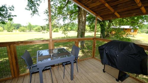 a screened in porch with a table and chairs at Les Cabanes de Lara in Ménesplet