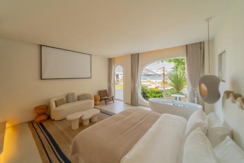 a bedroom with a large bed and a living room at 礼橖LoveTime·美学海景民宿（较场尾大鹏所城店） in Shenzhen