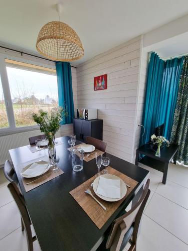 a dining room with a table with plates and glasses at Résidence de Nodeven in Guissény
