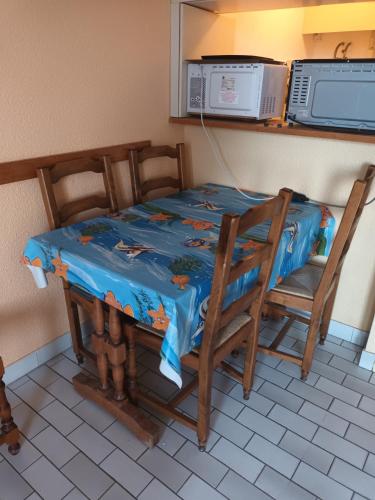 d'une table, de chaises et d'un four micro-ondes. dans l'établissement Appartement pour 5 avec piscine, au Cap d'Agde