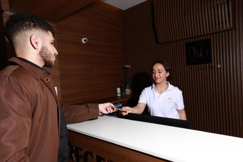 a man holding a cell phone in front of a woman at Nina Palace Hotel in Tbilisi City