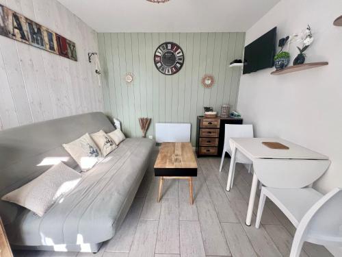 una sala de estar con un sofá y una mesa en Cabane au Bord du Lac - Les Jardins de Vandré - Parc Jeux Tennis Spa Nature - IDEAL FAMILLE, en Vandré