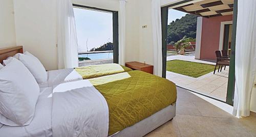 Un dormitorio con una cama y un balcón con vistas. en Άρκτος ΟΕ, en Pelekas