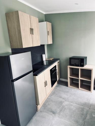 une petite cuisine avec un réfrigérateur et un micro-ondes dans l'établissement BeCo house, à Valenciennes
