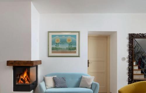 a living room with a blue couch and a fireplace at Beautiful Villa Palazzo Adriana Krk in Dobrinj