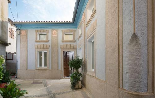 a building with a blue roof with a plant in a courtyard at Beautiful Villa Palazzo Adriana Krk in Dobrinj
