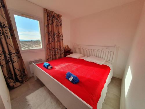 - une chambre avec un lit rouge et 2 serviettes dans l'établissement Bastide cozy Au petit olivier d 'Uzes, à Uzès