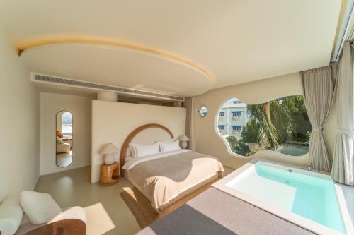 a bedroom with a bed and a tub at 礼橖LoveTime·美学海景民宿（较场尾大鹏所城店） in Shenzhen