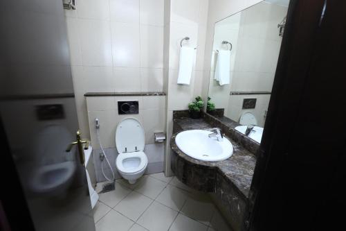 a bathroom with a toilet and a sink and a mirror at Naif Fort Hotel in Dubai