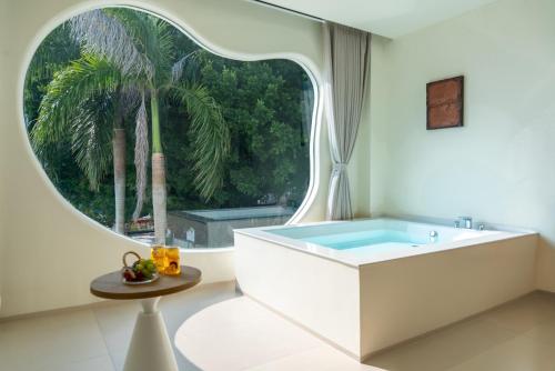 a bathroom with a tub and a large window at 礼橖LoveTime·美学海景民宿（较场尾大鹏所城店） in Shenzhen