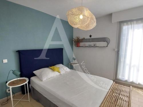 une chambre avec un grand lit et un lustre dans l'établissement T3 moderne, vue mer et parking, à Sète