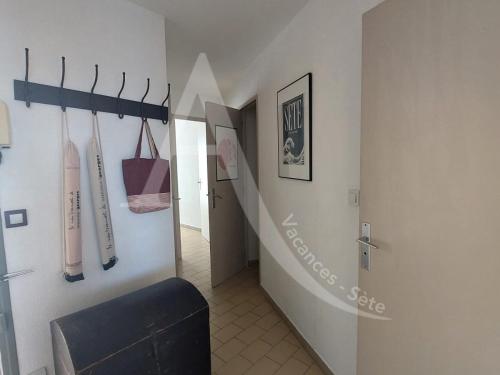 un couloir avec un escalier avec des battes de baseball sur le mur dans l'établissement T3 moderne, vue mer et parking, à Sète