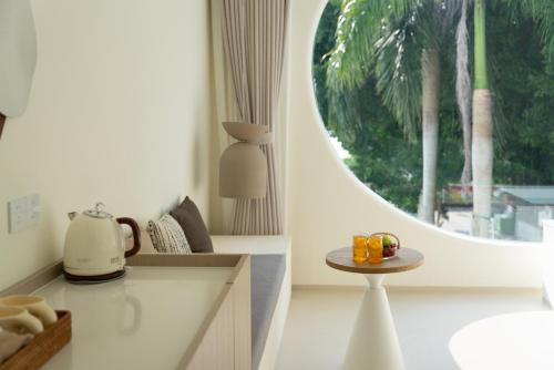 a kitchen with a table and a round window at 礼橖LoveTime·美学海景民宿（较场尾大鹏所城店） in Shenzhen
