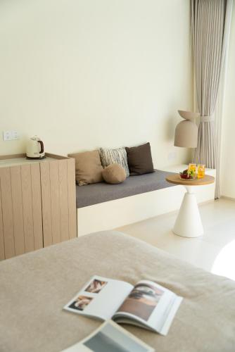 a bedroom with a bed with a couch in the background at 礼橖LoveTime·美学海景民宿（较场尾大鹏所城店） in Shenzhen