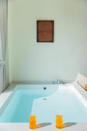 a bathtub in a white room with blue lighting at 礼橖LoveTime·美学海景民宿（较场尾大鹏所城店） in Shenzhen