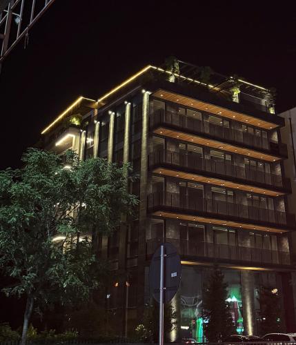 a tall building at night with a stop sign in front of it at Rigeli Apartments in Kosovo Polje