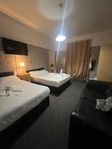 a hotel room with two beds and a couch at piccolo Hotel in Glasgow