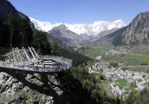 a suspension bridge over a valley in the mountains at Petite Maison des Alpes in Morgex