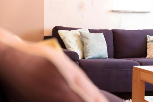 a purple couch with pillows in a living room at Hof in L i e b e s d o r f - Akelei in Gerabronn