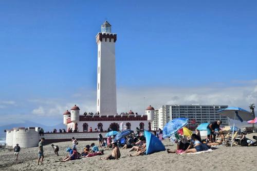 a group of people on the beach with a lighthouse at Pieza para 1 persona en el centro de La serena con desayuno in La Serena