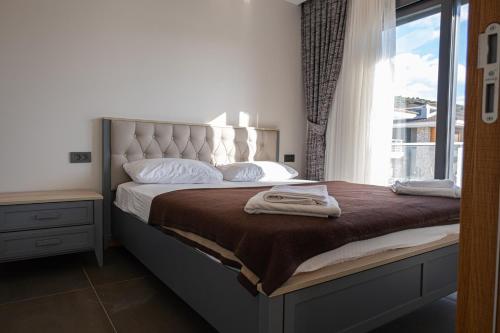Un dormitorio con una cama grande con ventana. en Çeşme lüks huzurlu yeni villa, en Cesme