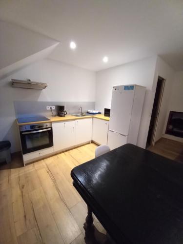 une cuisine avec un réfrigérateur et une table à l'intérieur dans l'établissement Agréable studio centre-ville Concarneau, à Concarneau