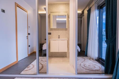 una puerta de cristal en una habitación con baño en Çeşme lüks huzurlu yeni villa, en Cesme