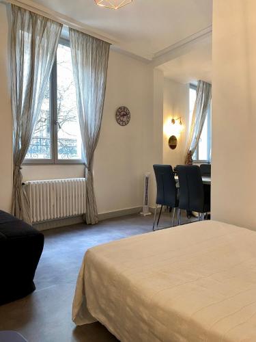 - une chambre avec un lit, des chaises et des fenêtres dans l'établissement Charmant 2 pièces au coeur de Paris, à Paris