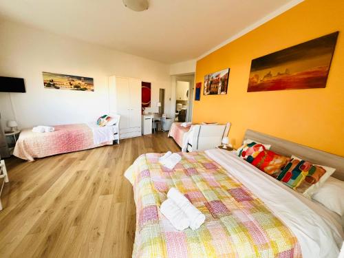 a bedroom with two beds and yellow walls at LeAlbe di Sicilia in Palermo