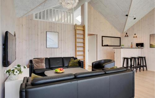 a living room with a black leather couch and a table at Gorgeous Home In Frederiksværk in Frederiksværk