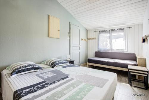 une chambre avec deux lits et une fenêtre dans l'établissement Superbe Villa T5 avec piscine privée proche plage et commerces climatisation et wifi, à Sainte-Marie-Plage