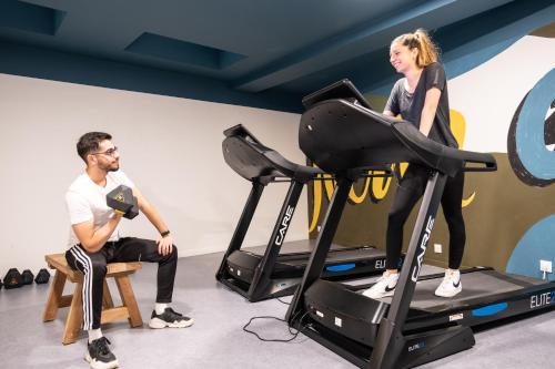 un homme et une femme sur un tapis roulant avec un homme assis sur un tabouret dans l'établissement Appartement cosy, à Bagneux