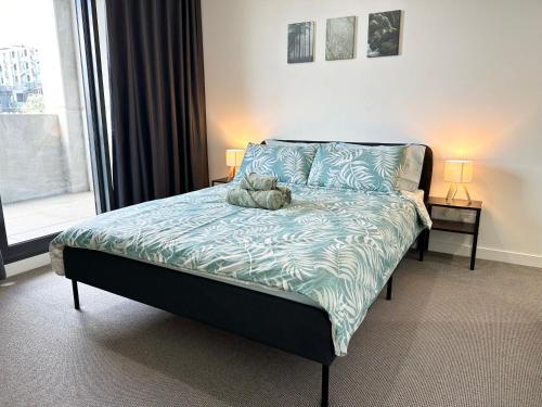 a bedroom with a bed with a teddy bear on it at Modern quiet two bedroom apt in Canberra City in Canberra