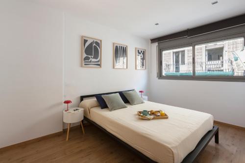 una camera da letto con un letto con un vassoio di cibo sopra di 4263 - AB Les Corts II a Barcellona