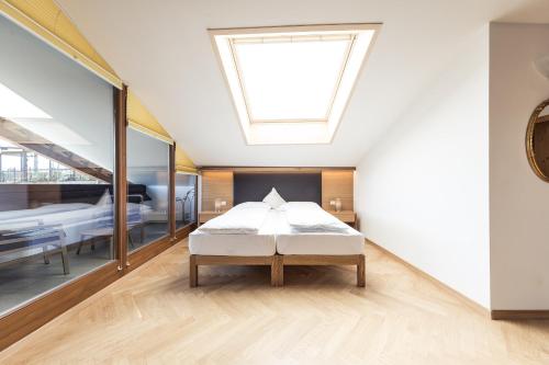 a bedroom with a bed and a skylight at Romantik Hotel Jagdhof in Caldaro
