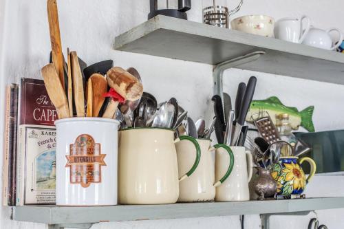 a shelf with several mason jars filled with utensils at Die Pomphuisie in Paternoster