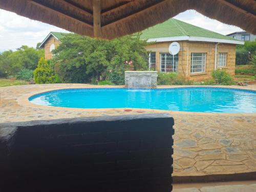 a swimming pool in front of a house at Bird Haven Guesthouse in Leribe