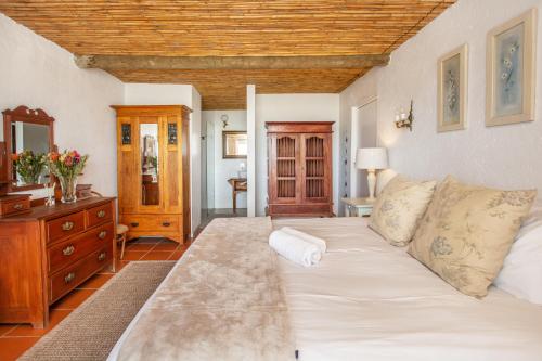 a living room with a large bed and a dresser at Die Pomphuisie in Paternoster