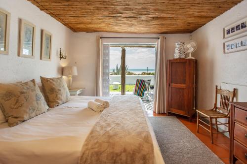 a bedroom with a bed with a view of the ocean at Die Pomphuisie in Paternoster