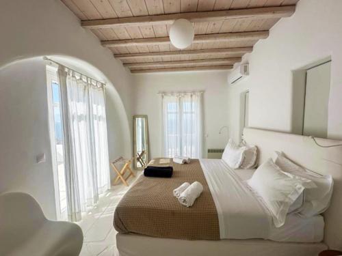 a bedroom with a large bed with towels on it at White Rock Suites & Villas in Houlakia