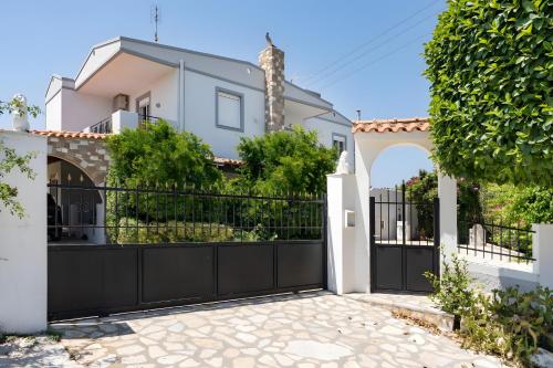 a black fence with a gate in front of a house at Villa Elysian in Antimácheia