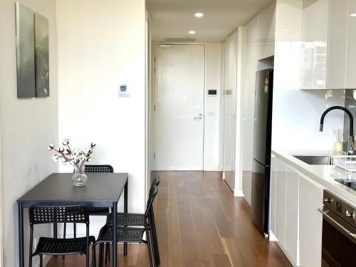 a kitchen with a table and chairs in a room at Modern quiet two bedroom apt in Canberra City in Canberra
