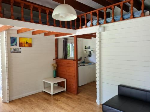 a room with white walls and a ceiling with a table at Cozy tiny house with swimming pool & outdoor sauna in Waasmunster