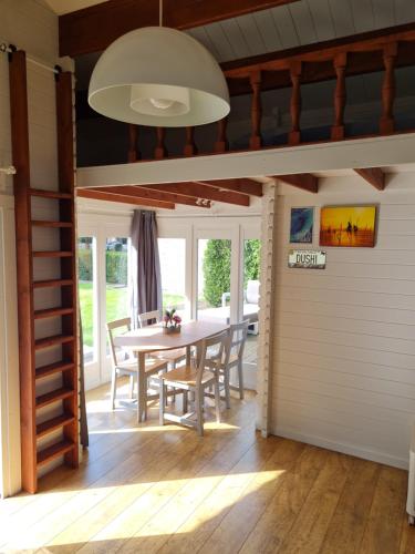 a dining room with a table and chairs at Cozy tiny house with swimming pool & outdoor sauna in Waasmunster