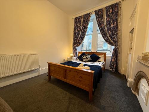 a bedroom with a bed and a window at 2 Bed Flat - Street Parking in Glasgow