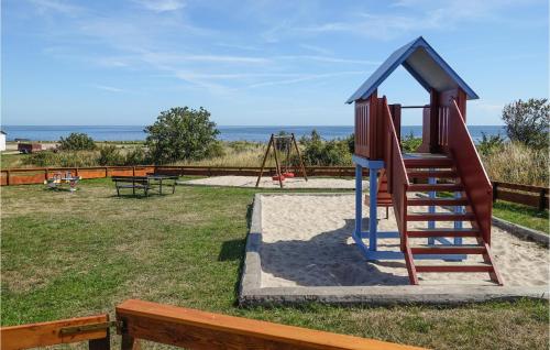 a playground with a slide and a swing at 1 Bedroom Nice Apartment In Svaneke in Svaneke