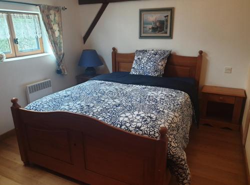 a bedroom with a bed with a blue comforter at La GRANGE de MOMBEL in Losse