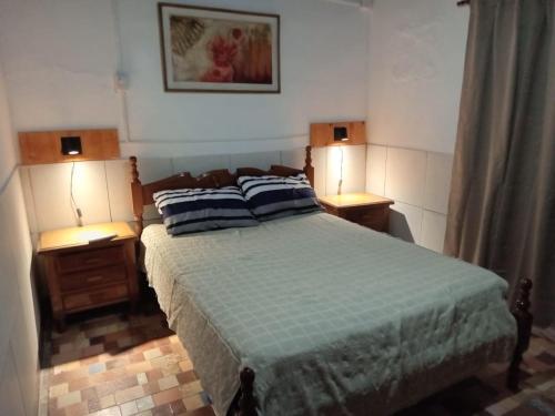 a bedroom with a bed with two night stands and two lamps at Chacra Don Joaquin 2 in La Cruz